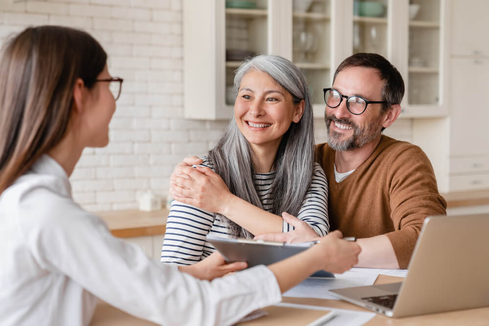 A couple meets with a financial advisor, exchanging ideas and insights about their financial future in a well-appointed office.