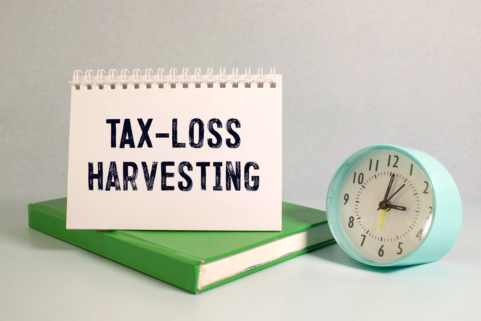 Tax Loss Harvesting illustration using a notebook and a clock